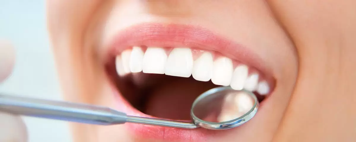 Une image détaillée d'un dentiste utilisant des outils pour éliminer le tartre des dents d'un patient.