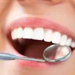 Une image détaillée d'un dentiste utilisant des outils pour éliminer le tartre des dents d'un patient.